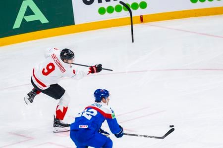 Slovenský obranca Samuel Kňažko sa snaží držať krok s kanadským rýchlikom Nathanom MacKinnonom.