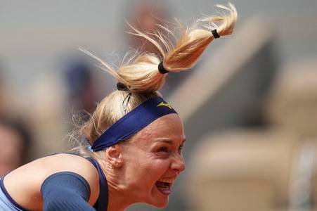 Rebecca Šramková odvracia úder Igy Swiatekovej počas zápasu 1. kola ženskej dvojhry na grandslamovom turnaji Roland Garros v Paríži.