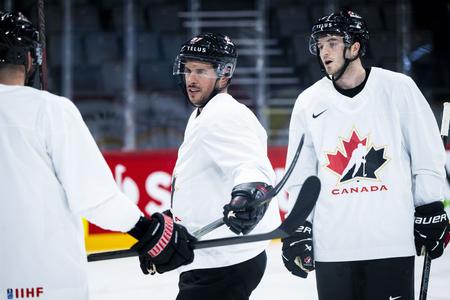 Uprostred kanadský hokejový reprezentant Sidney Crosby a vpravo spoluhráč Noah Dobson.