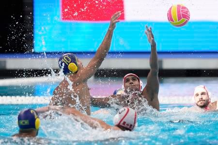 Brazílsky hráč Lucas Andrade (vľavo) sa pokúša skórovať cez Kanaďana Reuela Marka D'souzu v zápase C-skupiny Kanada - Brazília vo vodnom póle na MS v plaveckých športoch v Singapure.
