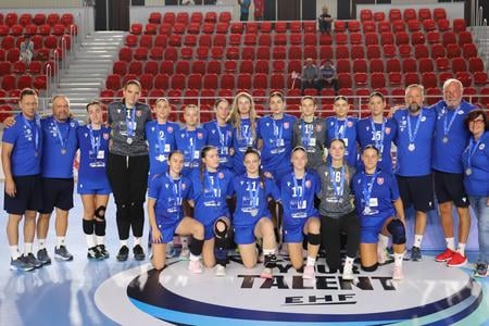 Reprezentácia slovenských hádzanárskych junioriek s medailami za 2. miesto na majstrovstvách EHF v gruzínskom Telavi. V hornom rade tretí sprava tréner Jan Beňadik.
