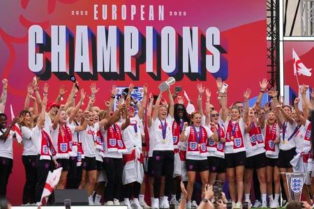 Kapitánka anglickej futbalovej reprezentácie Leah Williamsonová (uprostred) oslavuje so spoluhráčkami zisk titulu majsteriek Európy na pódiu pred Buckinghamským palácom.