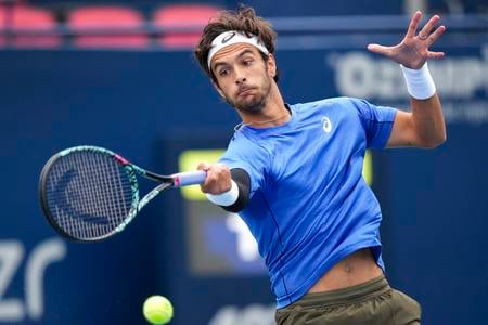 Taliansky tenista Lorenzo Musetti odvracia loptičku Američanovi Alexovi Michelsenovi počas zápasu 3. kola mužskej dvojhry na turnaji ATP Masters 1000 v kanadskom Toronte.