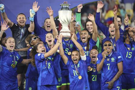 Brazílska futbalistka Marta (uprostred) drží trofej a raduje sa so spoluhráčkami po výhre vo finále Copa America žien proti Kolumbii v meste Quito.