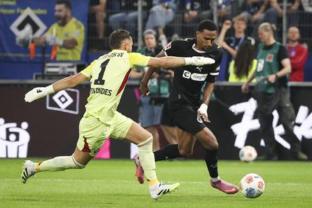 Andreas Hountondji z FC St. Pauli (vpravo) prekonáva brankára Hamburger SV Daniela Heuera Fernandesa.