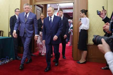 Russian President Vladimir Putin, centre, walks with Slovak Prime Minister Robert Fico, left, at Diaoyutai State Guesthouse in Beijing, China, on September 2, 2025.