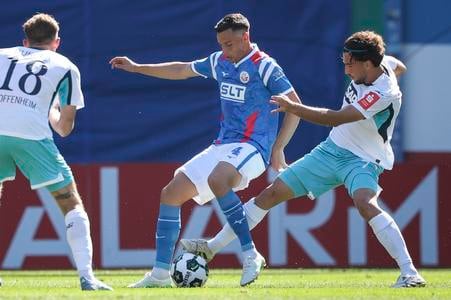 Leon Avdullahu (v strede) počas duelu Rostock - Hoffenheim. Vpravo Kenan Fatkič.