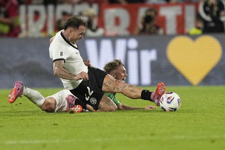 Nemecký reprezentant David Raum (vpredu) v súboji s Ethanom Galbraithhom.