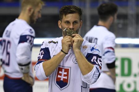 Jaroslav Martinusík v reprezentačnom drese bozkáva zlatú medailu na MS v hokejbale v roku 2019.