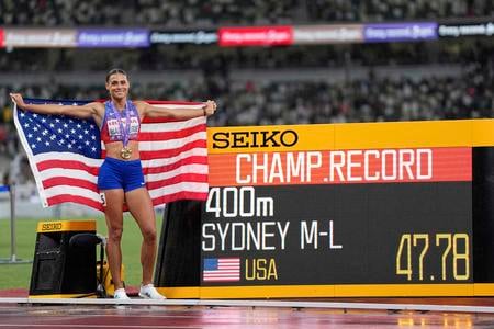 Americká bežkyňa Sydney McLaughlinová-Levroneová pózuje so zlatou medailou pri svetelnej tabuli s rekordom šampionátu, časom 47,78 s po jej víťazstve vo finále v behu na 400 m na atletických MS v Tokiu.