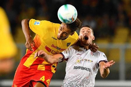 Obranca Lecce Tiago Gabriel (vľavo) hlavičkuje loptu pred útočníkom Cagliari Andreom Belottim.
