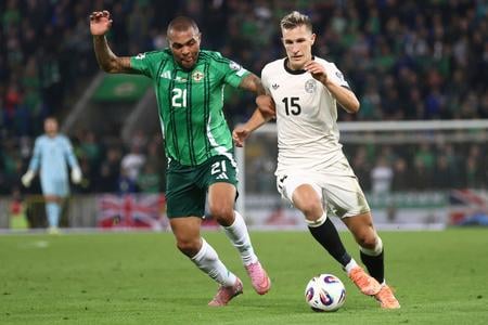 Nemec Nico Schlotterbeck (vpravo) uniká okolo Josha Magennisa v zápase kvalifikácie MS Severné Írsko - Nemecko.