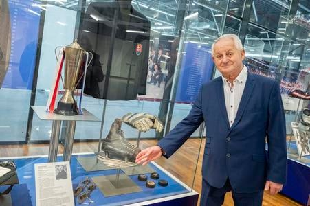 Člen Siene slávy slovenského hokeja a bývalý tréner slovenskej hokejovej reprezentácie Július Šupler si pozerá trofej a sako z kvalifikácie v Sheffielde z roku 1993, ktorú slovenskí hokejisti vyhrali a postúpili na olympijské hry do Lillehammeru v roku 1994. V dolnej časti sú korčule, rukavice a puky, ktoré Július Šupler daroval do Siene slávy slovenského hokeja. FOTO TASR - Martin Baumann