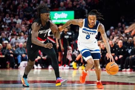 Bones Hylan z tímu Minnesota Timberwolves uniká Jrue Holidayovi z Portlandu.