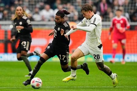 Na snímke futbalista Bayernu Michael Olise a hráč Mönchengladbachu  Luca Netz (vpravo) bojujú o loptu v zápase 8. kola nemeckej Bundesligy Borussia Mönchengladbach - Bayern Mníchov.