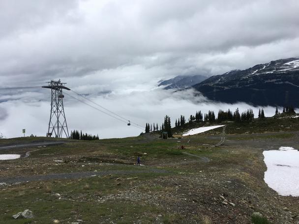 Jeden zo stožiarov Peak 2 Peak lanovky a kabínka miznúca v hmle