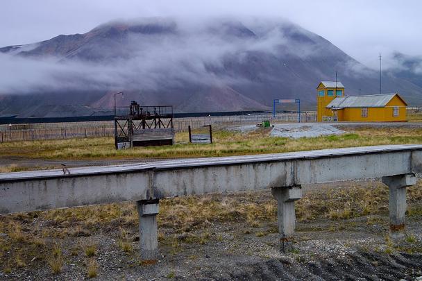 Priemyselne potrubie a za ním letisko/heliport.