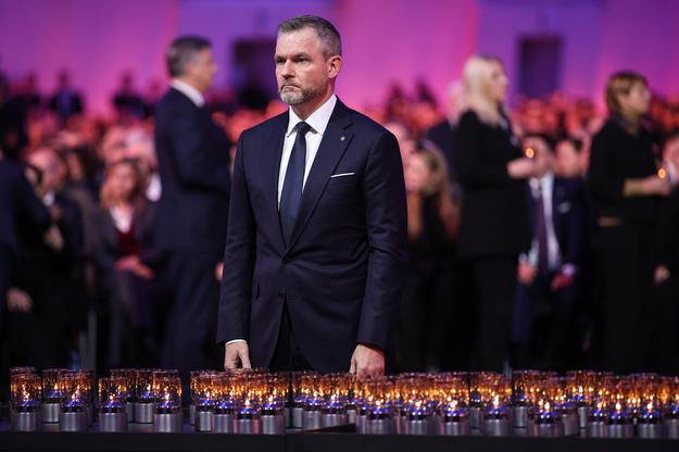 Slovak President Peter Pellegrini is lighting a candle during the commemoration of the 80th anniversary of the liberation of the Auschwitz-Birkenau concentration camp.