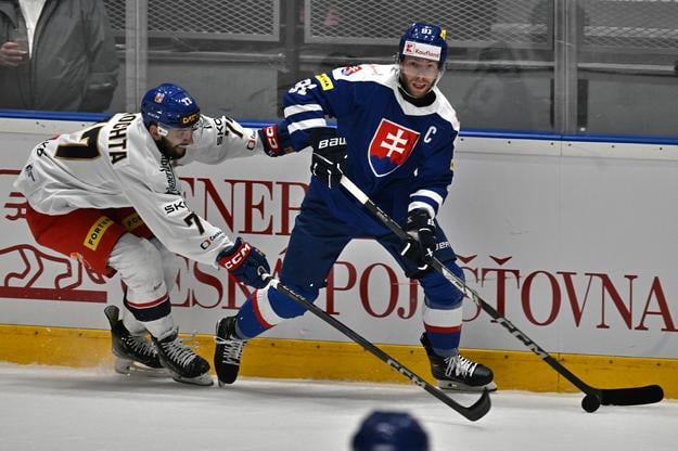 Na snímke sprava kapitán Matúš Sukeľ (Slovensko) a Filip Pyrochta (Česko) bojujú o puk pri mantineli v odvetnom prípravnom zápase Česká republika - Slovensko v Ostrave v piatok 25. apríla 2025. Vo štvrtok Slováci prehrali 0:4. Oba tímy sa pripravujú na májový svetový hokejový šampionát v Štokholme a Herningu.