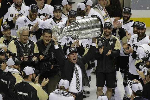 Na archívnej snímke z 12. júna 2016 tréner Pittsburghu Penguins Mike Sullivan zdvíha Stanleyho pohár po šiestom zápase finále zámorskej NHL proti San Jose Sharks
