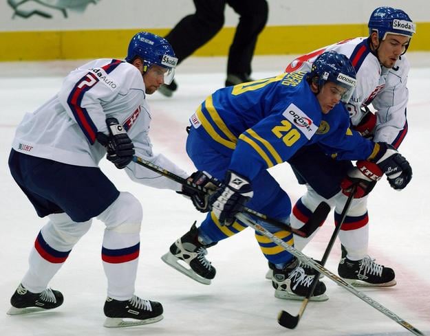Henrik Zetterberg medzi Martinom Štrbákom (vľavo) a Miroslavom Šatanom v semifinále MS 2002 v Göteborgu.
