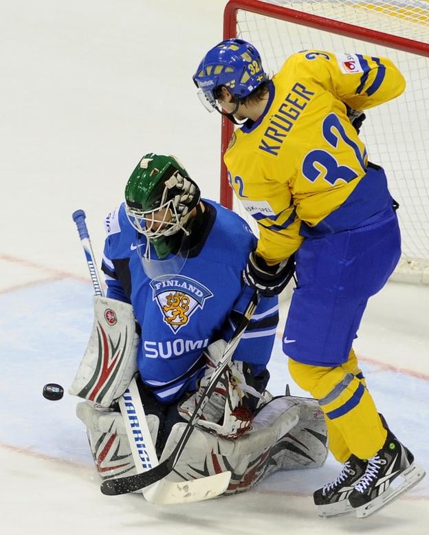 Na snímke vpravo Marcus Kruger (Švédsko) a vľavo brankár Petri Vehanen (Fínsko) vo finále MS v ľadovom hokeji 2011 Fínsko - Švédsko 15. mája 2011 v Bratislave.