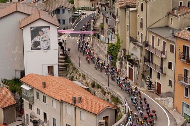 Cyklistický pelotón prechádza okolo budovy s maľbou talianskej astronautky Samanthy Cristoforettiovej počas 6. etapy cyklistických pretekov Giro d'Italia na trati Potenza - Neapol, dlhej 227 km v talianskom meste Potenza.