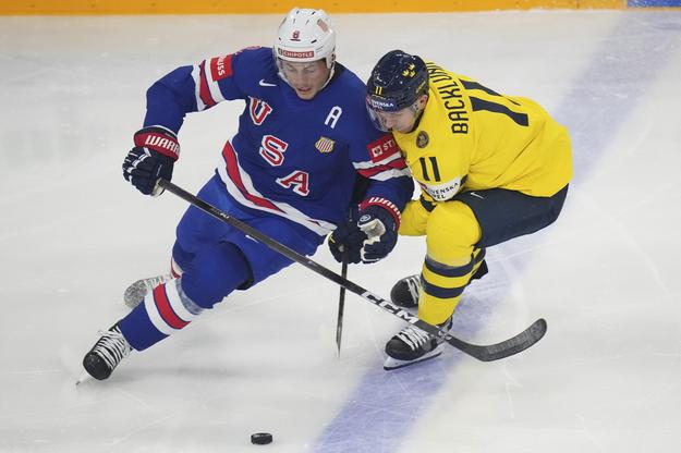 Mikael Backlund (vpravo) bojuje o puk s Američanom Zachom Werenskim v zápase semifinále Švédsko - USA 2:6.