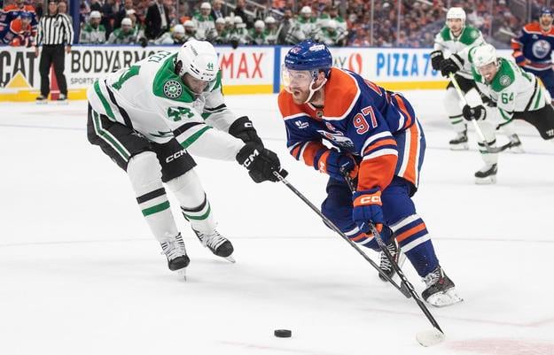 Connor McDavid (vpravo) bojuje o puk s hokejistom Dallasu Cody Cecim.