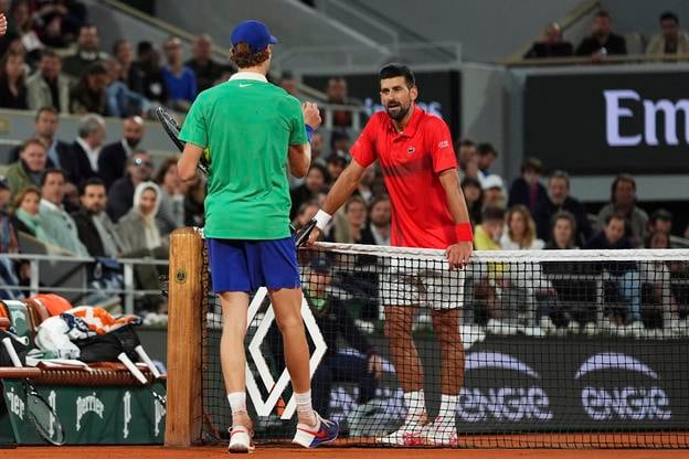 Srbský tenista Novak Djokovič (vpravo) a taliansky tenista Jannik Sinner sa rozprávajú v semifinále mužskej dvojhry.