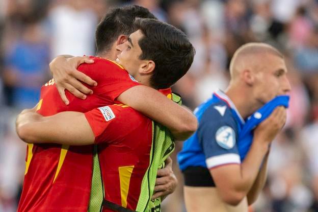 Spain footballers celebrate their 3-2 victory over Slovakia in what UEFA described as a thrilling game. In the background is Jakub Jakubko from team Slovakia.