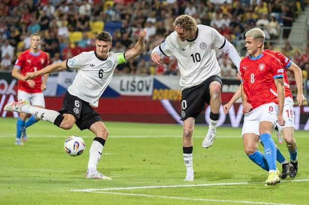 Eric Martel (Nemecko) strieľa gól, uprostred jeho spoluhráč Nick Woltemade a vľavo Denis Halinský (Česko) počas zápasu základnej B-skupiny ČR - Nemecko na ME  hráčov do 21 rokov v Dunajskej Strede.