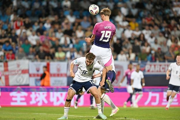 Uprostred futbalista Nemecka Nelson Weiper dáva gól hlavou na 2:0.