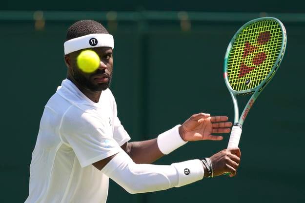 Frances Tiafoe odvracia loptičku Dánovi Elmerovi Möllerovi v 1. kole mužskej dvojhry na grandslamovom turnaji Wimbledon.