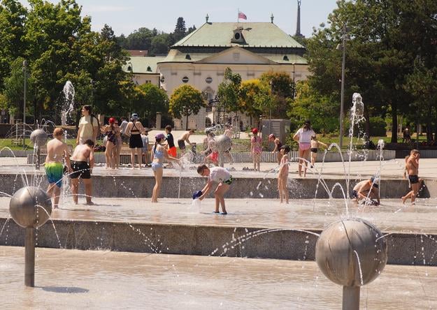 Children and adults enjoy a hot summer day in the Družba fountain on Freedom Square in Bratislava on 3 July 2025.
