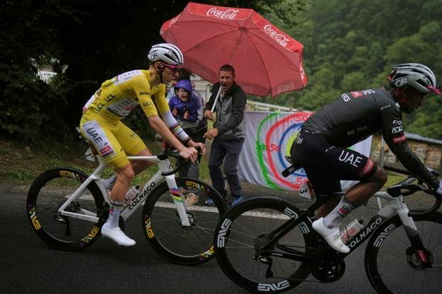 Slovinský cyklista Tadej Pogačar v žltom drese vedúceho pretekára a Ekvádorčan Jhonatan Narvaez (vpravo) počas 14. etapy cyklistických pretekov Tour de France.