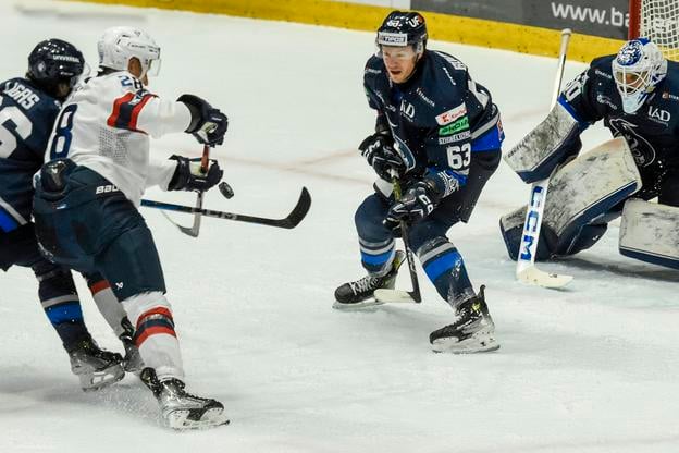 Trent Bourque bráni pred brankárom Ádámom Vayom nájazd Richarda Pánika zo Slovanu.
