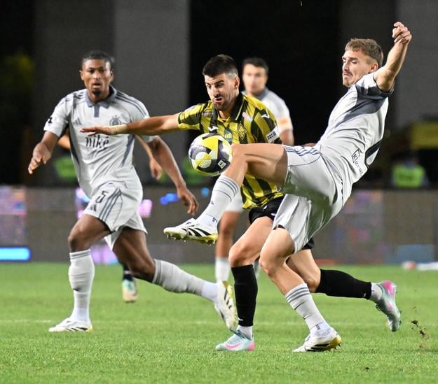 Rahim Ibrahim, hráč Almaty Valerij Gromyko a hráč Slovana Peter Pokorný bojujú o loptu počas zápasu 3. predkola Ligy majstrov Kajrat Almaty - Slovan Bratislava.