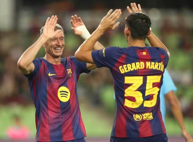 Hráč FC Barcelony Robert Lewandowski (vľavo) sa raduje z gólu so spoluhráčom Gerardom Martinom počas priateľského futbalového zápasu FC Barcelona - Daegu.