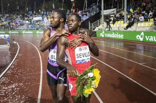 Jamajský bežec Oblique Seville (vpravo) oslavuje s tretím Jamajčanom Ackeemom Blakeom po behu na 100 m na atletickom mítingu Diamantovej ligy vo švajčiarskom Lausanne.