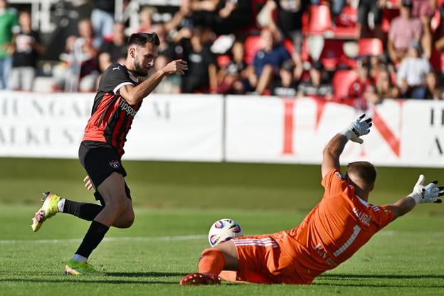 Trnavčan Štefan Škrbo pred brankárom Komárna Filipom Dlubáčom počas zápasu 5. kola Niké ligy.