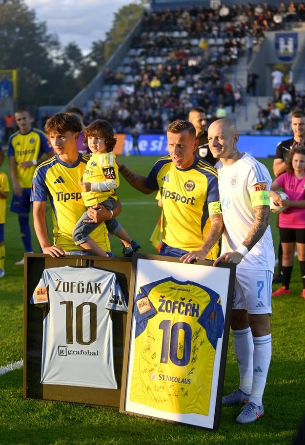 Kapitáni oboch tímov Igor Žofčák a Vladimír Weiss ml. pózujú pri zarámovaných dresoch.