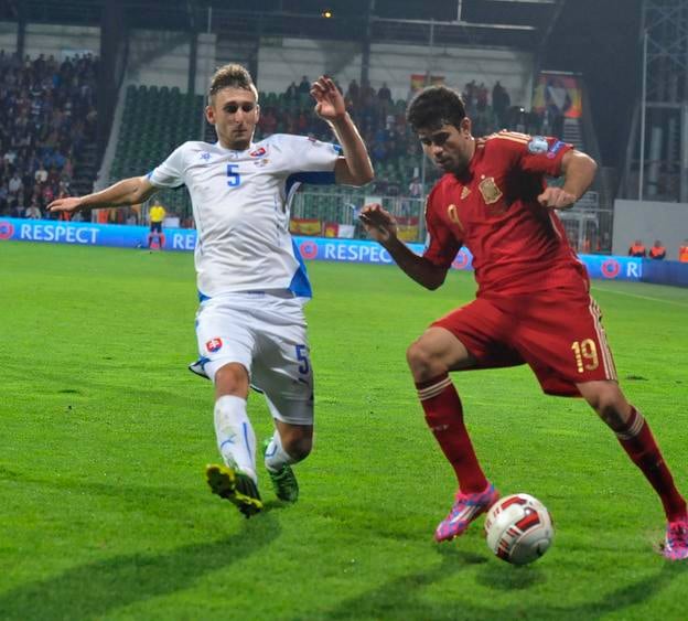 V októbri 2014 bol v základnej zostave Slovenska proti Španielsku aj Norbert Gyömbér (vľavo, v súboji s Diegom Costom), ktorý prispel o jedenásť rokov neskôr aj proti ďalšiemu pamätnému triumfu nad Nemeckom. 