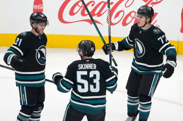 Hokejisti San Jose Sharks' Alexander Wennberg (21), Jeff Skinner (53) a Michael Misa (77) oslavujú gól v sieti Los Angeles Kings.