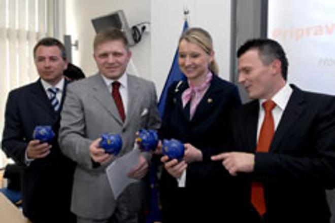 Clutching their euro-piggy banks, PM Robert Fico (second left), Finance Minister Ján Počiatek (far right) and Cabinet Appointee on the Euro Igor Barát welcomed the European Commission's decision to back Slovakia's entry into the eurozone.