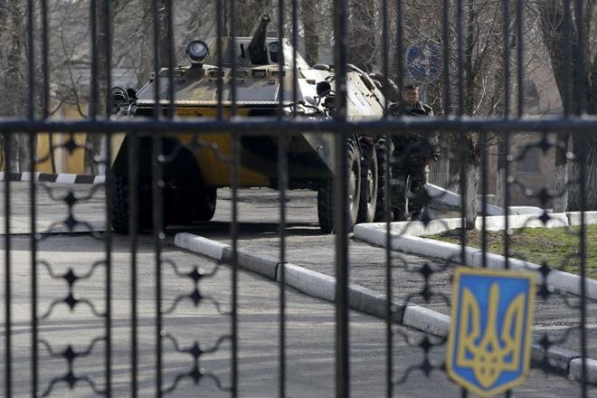 A Ukrainian armored personnel carrier is stationed behind the gate of a military base in the port of Kerch, Ukraine, on March 3, 2014.