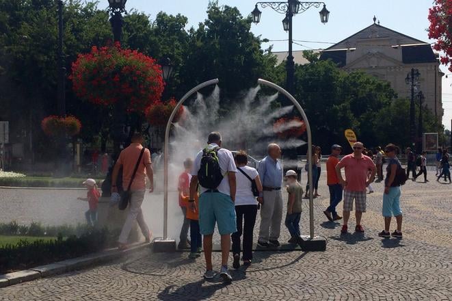 People enjoy the misting system at Hviezdoslavovo square.