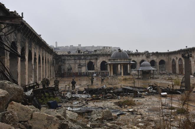 Syrian troops and pro-government gunmen marching walk inside the destroyed Grand Umayyad mosque in the old city of Aleppo, Syria.
