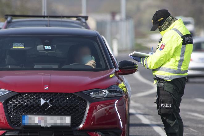 A police officer checks a vehicle in Bratislava during the coronavirus outbreak on April 6, 2020. 