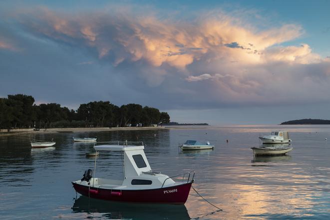 Due to the lack of tourists, the beach is empty and only few boats are moored in the harbor in Fazana, Croatia.